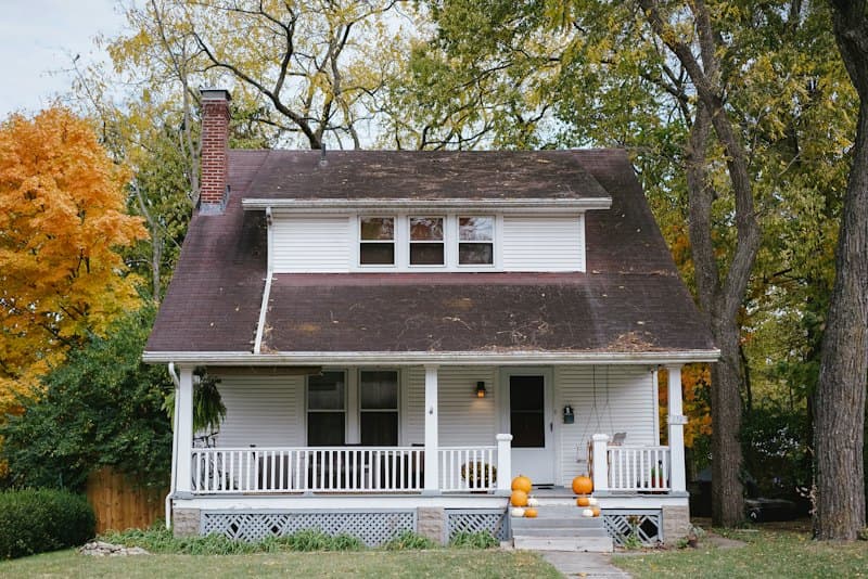 A two-storey family home with a front porch in autumn